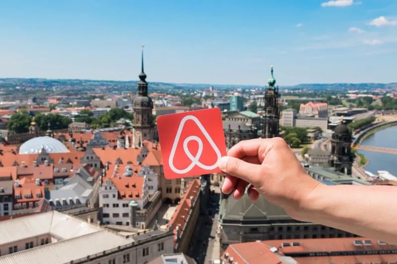 Airbnb Logo mit Stadthintergrund