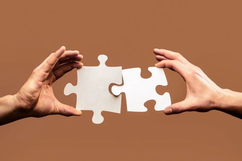 Weiße Puzzleteile greifen ineinander
